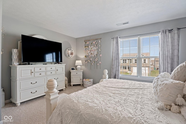 bedroom with light carpet, visible vents, and a textured ceiling