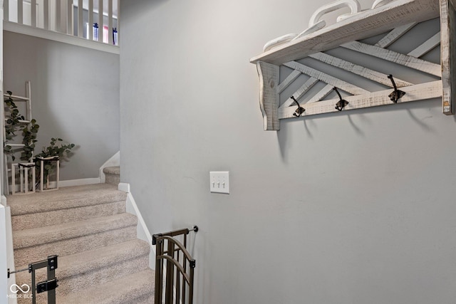 staircase featuring carpet flooring and baseboards