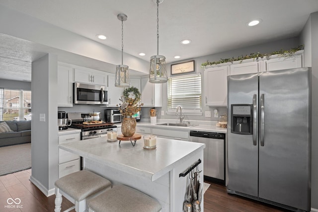 kitchen featuring stainless steel appliances, light countertops, white cabinetry, and a sink