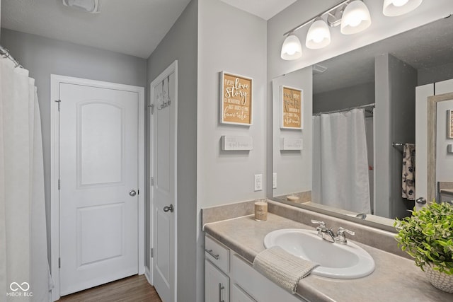 full bathroom featuring wood finished floors and vanity