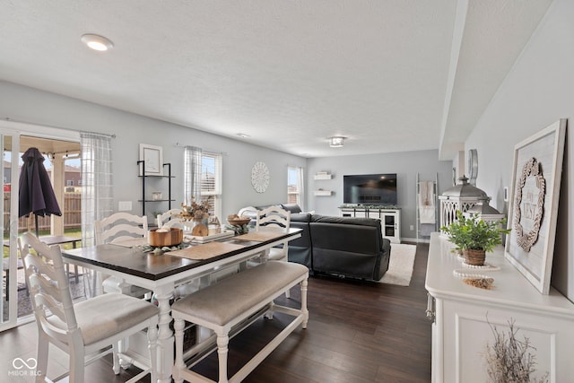 dining area with dark wood-style floors and a textured ceiling