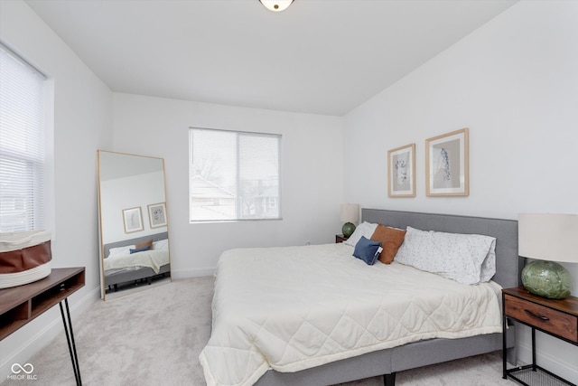 bedroom featuring multiple windows, baseboards, and carpet flooring