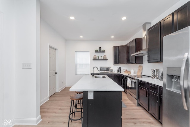 kitchen featuring a sink, appliances with stainless steel finishes, wall chimney range hood, light wood-type flooring, and open shelves