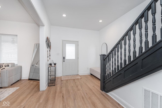 foyer entrance with baseboards, visible vents, stairway, wood finished floors, and recessed lighting