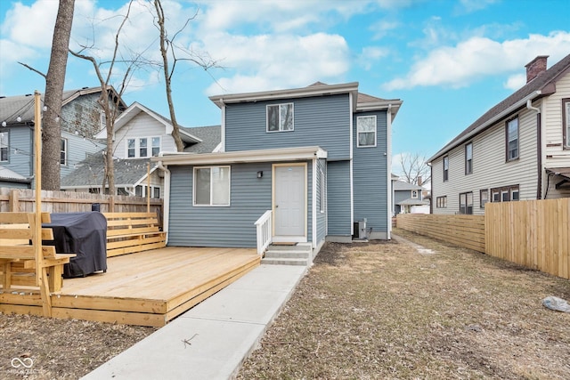 rear view of property with a residential view, fence, a deck, and entry steps