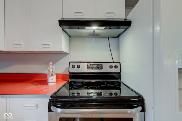 kitchen with under cabinet range hood, white cabinets, and electric range