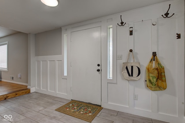 entrance foyer with wood tiled floor and a decorative wall