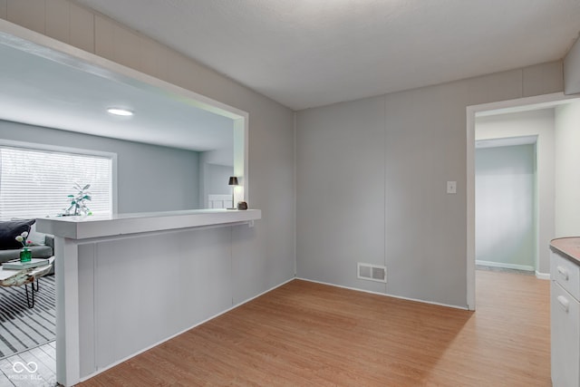 interior space with light wood-style flooring and visible vents