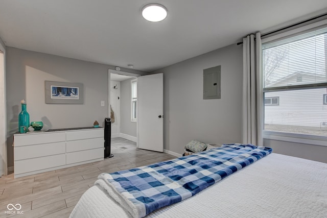 bedroom featuring electric panel, baseboards, and wood finish floors