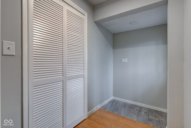 hall with baseboards and wood finished floors