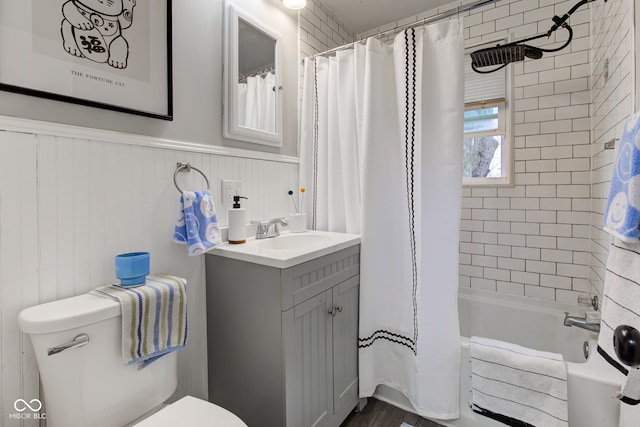 full bathroom with toilet, a wainscoted wall, shower / bath combo, and vanity