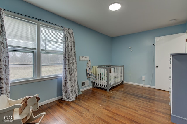 bedroom featuring baseboards, visible vents, and hardwood / wood-style floors