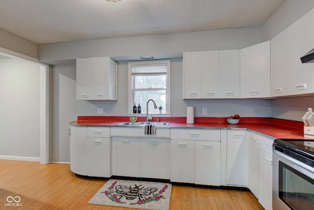 kitchen with white cabinetry, light wood-style flooring, stainless steel electric stove, and a sink