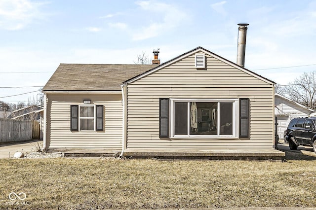 exterior space with fence and a shingled roof