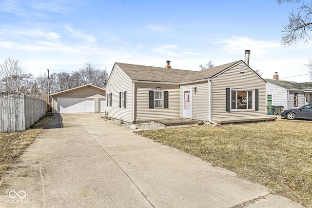 bungalow featuring a detached garage, fence, a front yard, and an outdoor structure