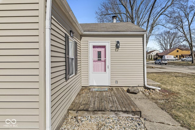 entrance to property featuring a shingled roof