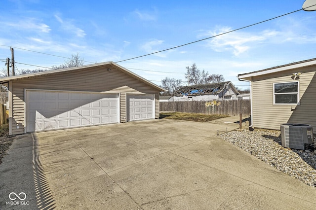 detached garage featuring central air condition unit and fence