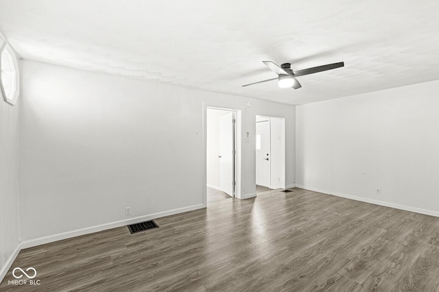 empty room with visible vents, ceiling fan, baseboards, and wood finished floors