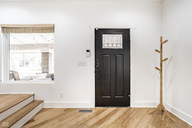 entryway with visible vents, stairs, baseboards, and wood finished floors