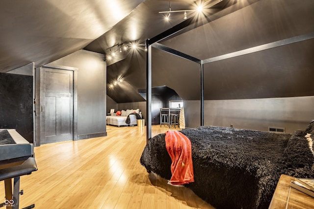 bedroom featuring lofted ceiling, visible vents, and hardwood / wood-style floors