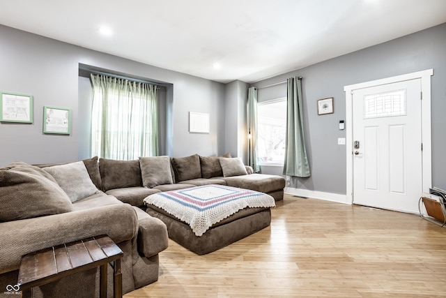 living area featuring baseboards, light wood-type flooring, plenty of natural light, and recessed lighting