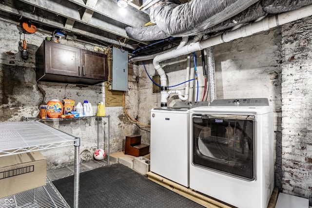 clothes washing area featuring laundry area, electric panel, and washing machine and clothes dryer