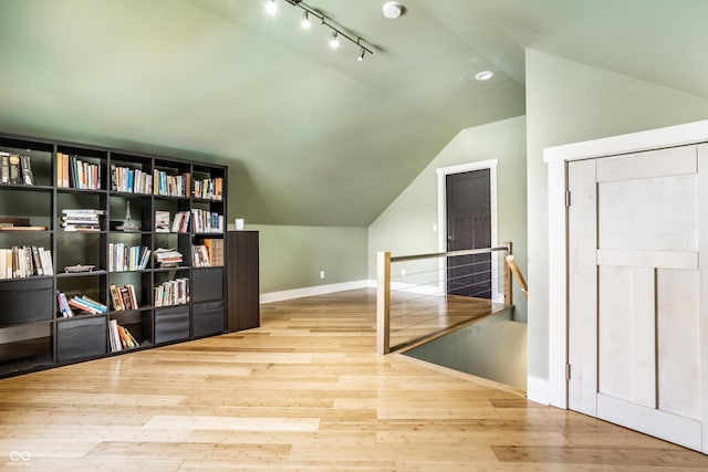 additional living space with vaulted ceiling, baseboards, and wood finished floors