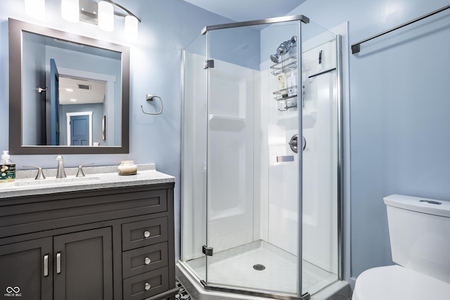 bathroom featuring a stall shower, vanity, and toilet