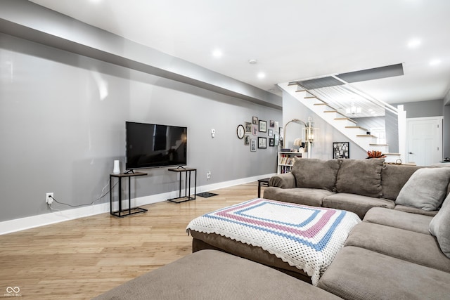 living area with recessed lighting, stairway, baseboards, and wood finished floors