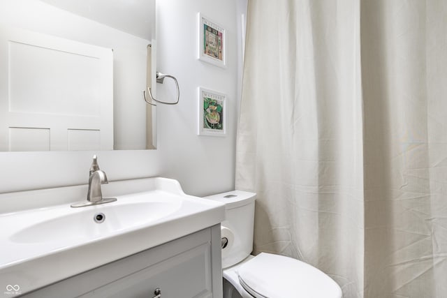 bathroom with a shower with curtain, vanity, and toilet