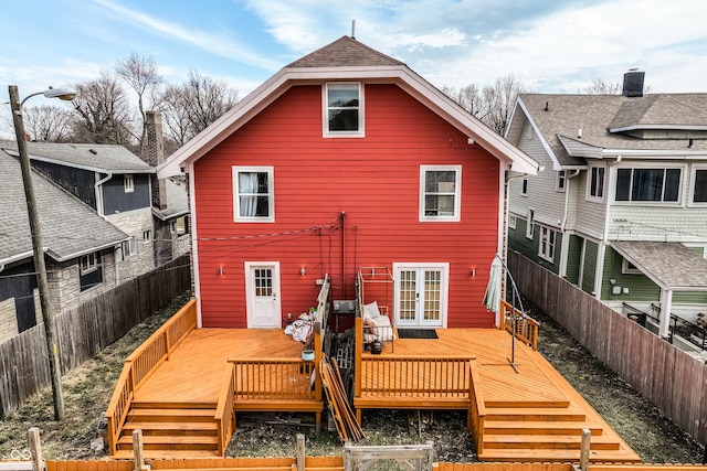 back of property with a fenced backyard, a wooden deck, and french doors