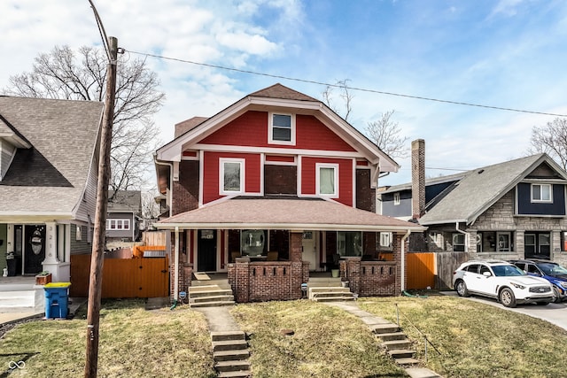 view of front of home featuring covered porch, stairway, and fence