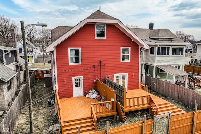 back of property featuring a deck, a shingled roof, and a fenced backyard