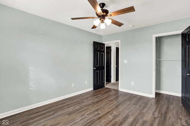 unfurnished bedroom featuring dark wood-style flooring, a closet, a ceiling fan, and baseboards