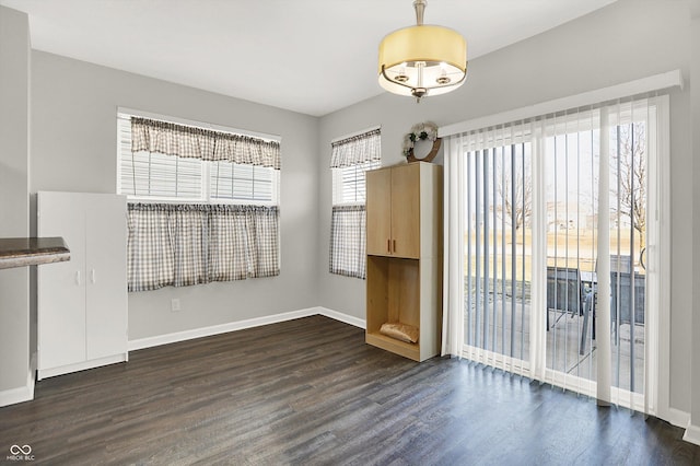 unfurnished dining area featuring wood finished floors and baseboards