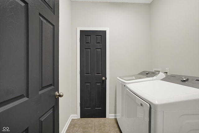 laundry area featuring laundry area, baseboards, light tile patterned flooring, and washing machine and clothes dryer