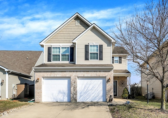 traditional-style house featuring a garage, concrete driveway, and brick siding