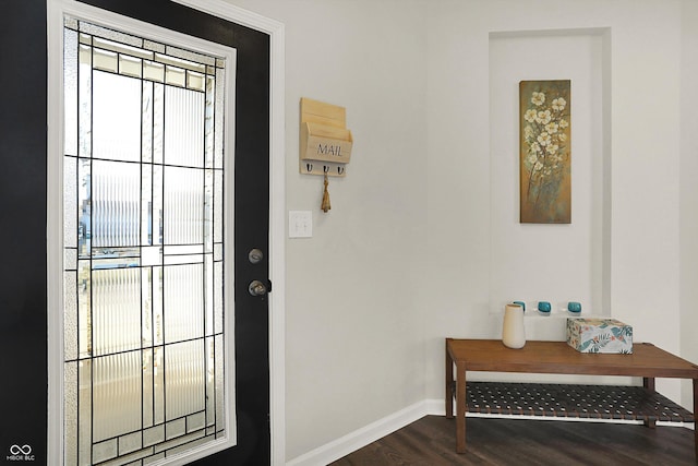 doorway to outside with dark wood finished floors and baseboards