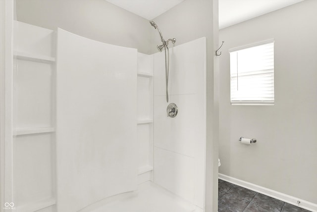 full bath featuring a shower, tile patterned floors, and baseboards