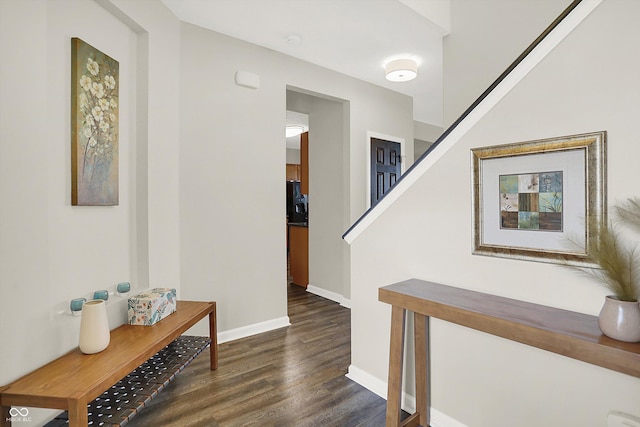 corridor featuring dark wood-style flooring and baseboards