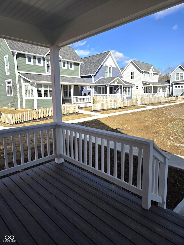 wooden terrace featuring a porch, fence, and a residential view