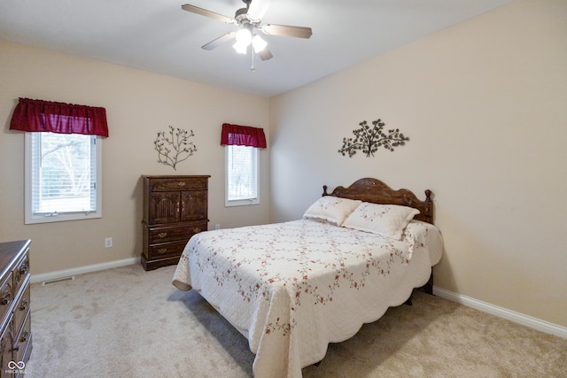 bedroom featuring multiple windows, baseboards, and light colored carpet