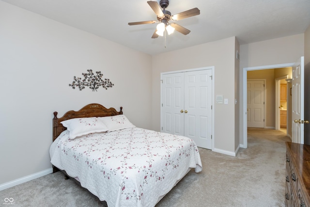 bedroom featuring a closet, light colored carpet, ceiling fan, and baseboards