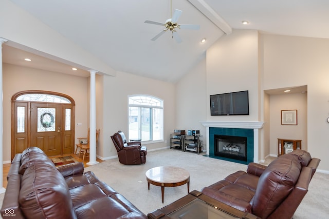 carpeted living room with beam ceiling, ornate columns, high vaulted ceiling, a tile fireplace, and baseboards