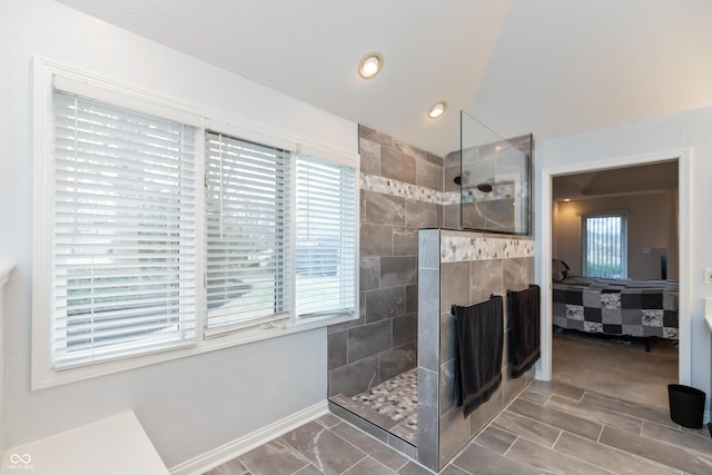 bathroom featuring lofted ceiling, a walk in shower, a fireplace, and ensuite bathroom