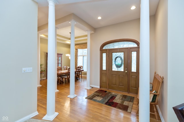 entrance foyer featuring ornate columns, baseboards, light wood finished floors, and recessed lighting