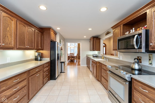 kitchen featuring light countertops, stainless steel appliances, a sink, and recessed lighting