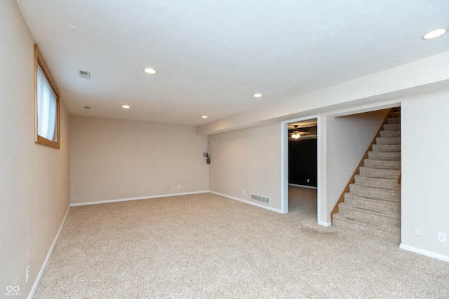 below grade area featuring carpet floors, recessed lighting, visible vents, and baseboards