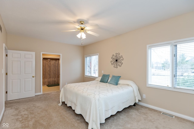 bedroom featuring light carpet, baseboards, multiple windows, and visible vents