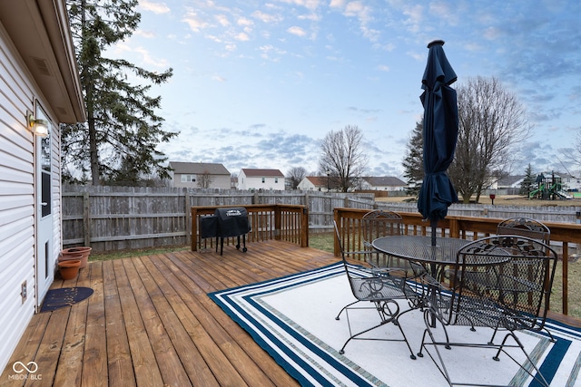 deck with outdoor dining space and a fenced backyard